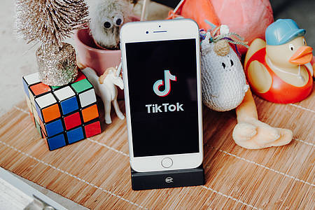 Spielzeug und Handy mit TikTok-App auf dem Display
