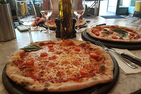 Zwei Teller mit Pizza stehen auf einem Restauranttisch