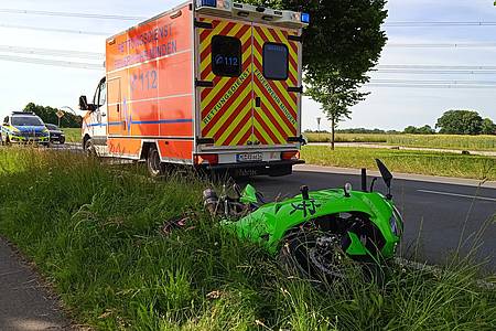 Motorrad liegt am Straßenrand vor Rettungswagen