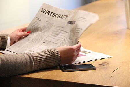 Frau liest den Wirtschaftsteil einer Zeitung